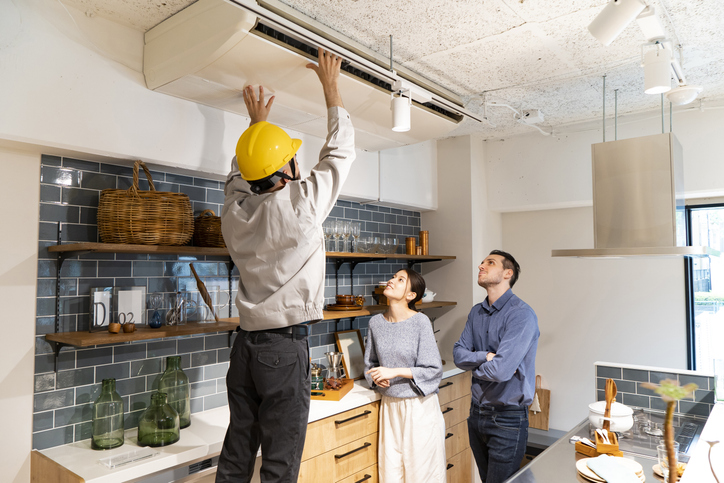 Home inspector showing a couple some findings in the kitchen