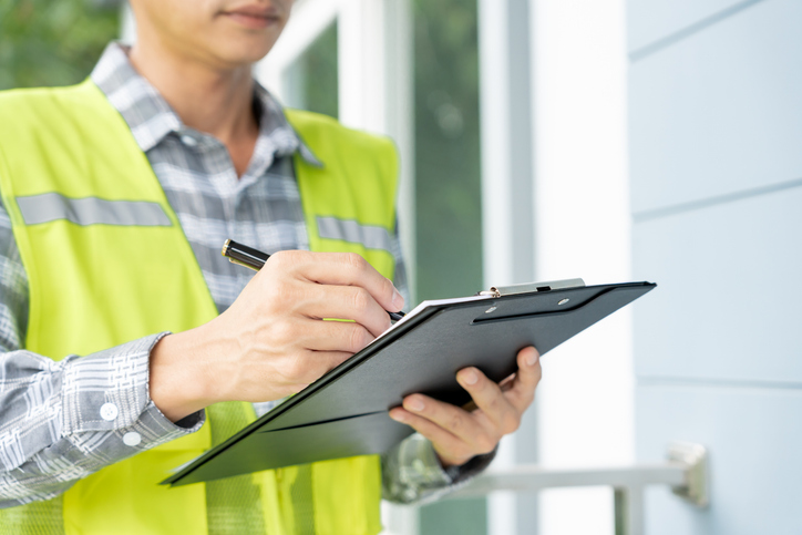 inspector is inspecting construction and quality assurance of a new house using a checklist.